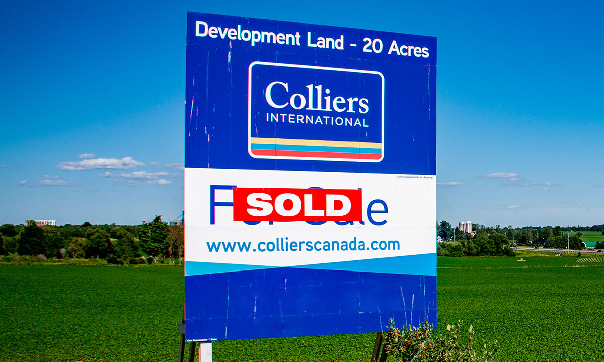 for sale sign on available development land with sold sticker