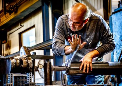 photo of a worker using a wrench to adjust some machinery