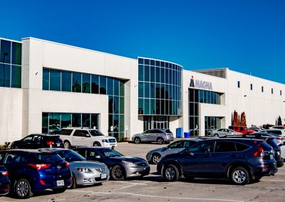 photo of the front of the Magna company building and accompanying parking lot